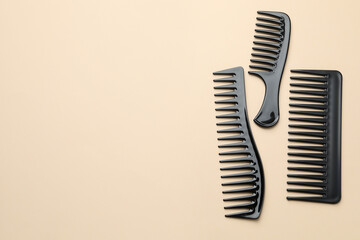 Different black plastic combs on beige background, top view. Space for text