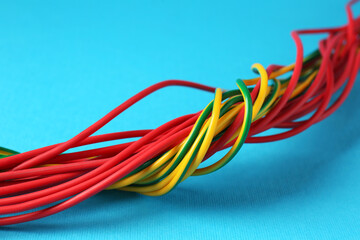 Many color electrical wires on light blue background, closeup
