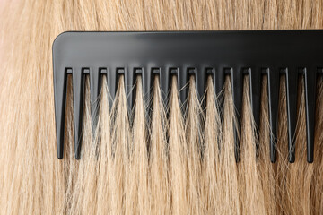 Brushing hair with plastic comb, closeup view