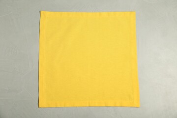 Yellow napkin on light grey table, top view