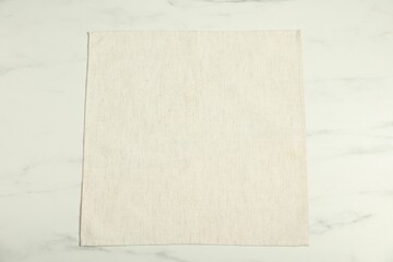 Light napkin on white marble table, top view
