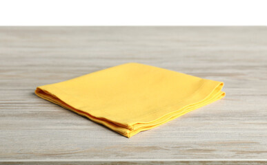 Yellow napkin on wooden table against white background
