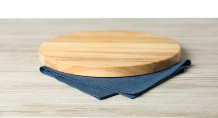 Blue napkin and empty board on wooden table against white background