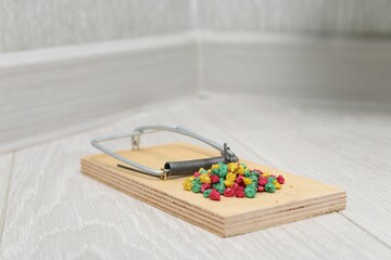 Mouse trap with rat poison on floor indoors, closeup