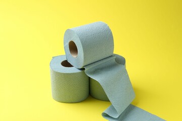 Light blue toilet paper rolls on yellow background