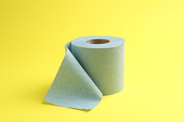 Light blue toilet paper roll on yellow background