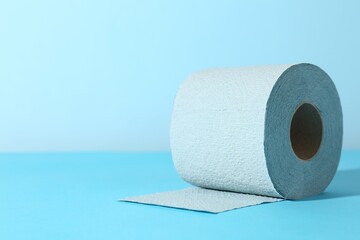Light blue toilet paper roll on color background, closeup. Space for text