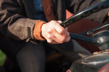 Close up of woman farmer's hands holding steering wheel of tractor, celebrating her contribution to agriculture on international workers' day