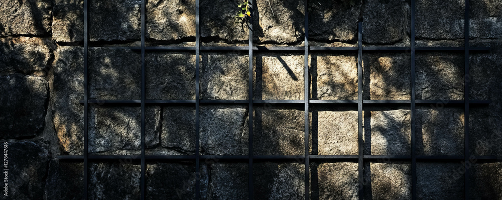 Poster Black square grid on textured dark stone wall with shadow patterns