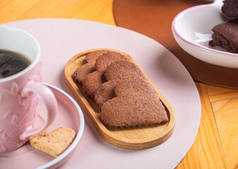 Delicious heart-shaped cookies served with coffee on a wooden tray, perfect for a cozy afternoon snack, inviting and warm, ideal for sharing, sweet treat concept