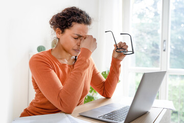 Woman feeling tired and overworked working from home