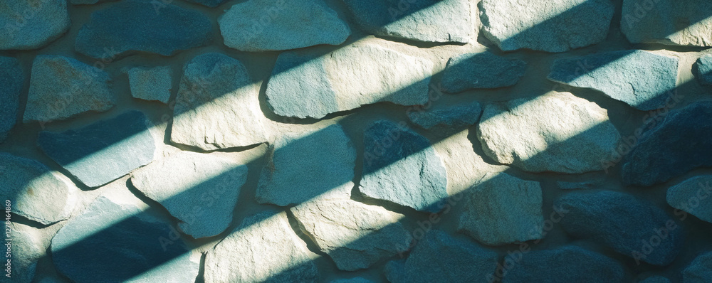 Poster sunlit stone wall with deep vertical ribs and dramatic shadows for architecture and design inspirati