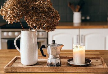 Selective focus on dried Hydrangea flowers in a jug shape vase on rustic wooden tray, retro...