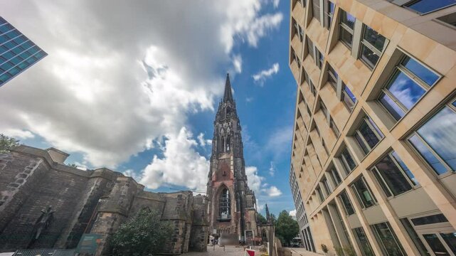 Looking up perspective to the facade of Ehemalige Hauptkirche St. Nikolai timelapse hyperlapse, the bell tower of the burned Church of St. Nicholas in Hamburg, Germany. Iconic neogothic memorial site