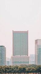 Obraz premium City skyline view with tall building, park trees in foreground. Possible use Stock photo