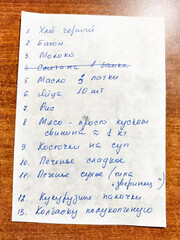 Grocery list written in handwritten notes on a wooden table surface