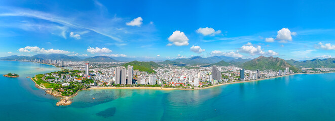 Naklejka premium Beach overlooking panoramic aerial view city on the coast cliff of Southeast Asia in the bright morning sunrise Nha Trang