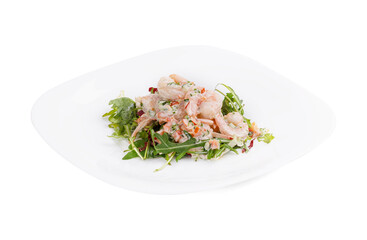 A white plate with shrimp salad and greens on a white background