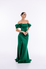 Beautiful brunette girl in a green and emerald evening dress on a white background isolated