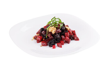 A white plate topped with a fresh salad of berries and walnuts