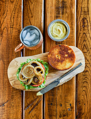 hamburger topped with lettuce, tomato, and grilled onions