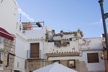 Whitewashed buildings with a Mediterranean feel. Architectural details, aged textures, and a sunny sky.
