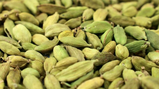 Dried green cardamom pods condiment texture circle rotation close up