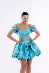 Naklejka premium Sexy mulatto girl in a short evening luxury turquoise dress on a white background