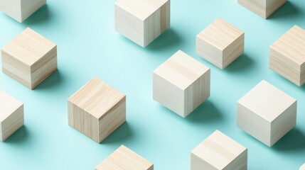 Fototapeta premium Pastel blue background with scattered wooden and white cubes.