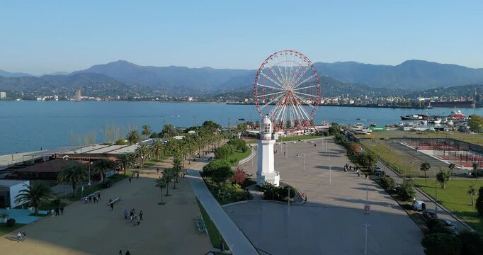 Bird&rsquo;s-eye drone footage showcasing Batumi&rsquo;s vibrant waterfront, highlighting the Ferris wheel, marina, and shimmering sea on a warm afternoon.  