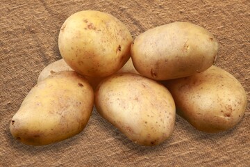 Ripe fresh potatoes on wooden desk