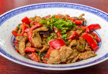 Chinese dish with pork meat, cilantro  and red peppers