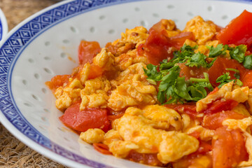 Chinese dish with fried egg, tomato and cilantro