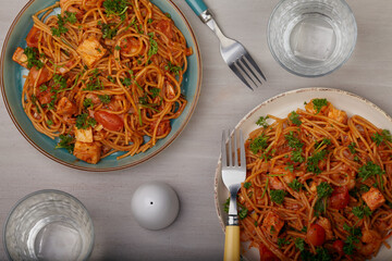 Seafood and pasta dish shot from above with a grey background.