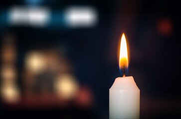 A single candle flame in a dark space