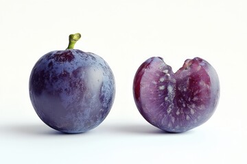 Obraz premium A whole plum and a halved plum on a white background