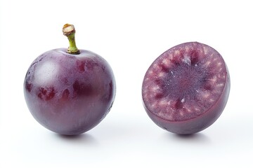 Obraz premium A single dark grape and its halved counterpart