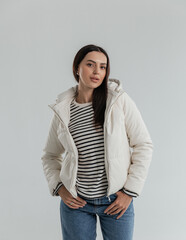 Portrait of a cute girl model in a leather white jacket and striped sweater
