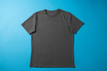 One blank t-shirt on light blue background, top view. Mockup for design