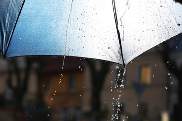 Open umbrella under pouring rain outdoors, closeup