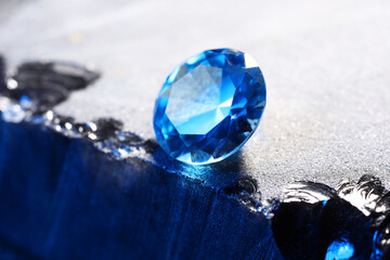 Beautiful shiny light blue gemstone on stone, closeup
