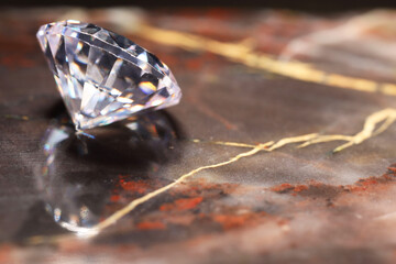 Beautiful shiny gemstone on brown marble surface, closeup. Space for text