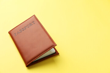 Passport in bright cover on yellow background, closeup. Space for text