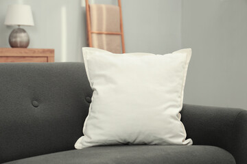 Blank soft pillow on cozy couch indoors
