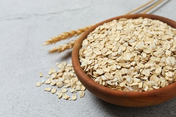 Composition with oatmeal flakes on gray background. Cooking breakfast