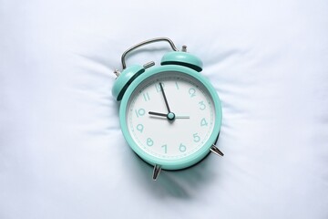 Alarm clock on pillow, top view. Time for sleeping