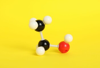 Molecule of ethanol on yellow background. Chemical model