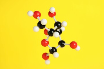 Molecule of glucose on yellow background. Chemical model