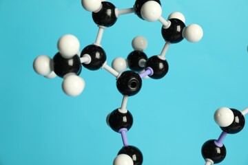 Molecule of retinol (vitamin A) on light blue background, closeup. Chemical model
