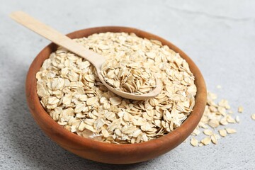 Composition with oatmeal flakes on gray background. Cooking breakfast